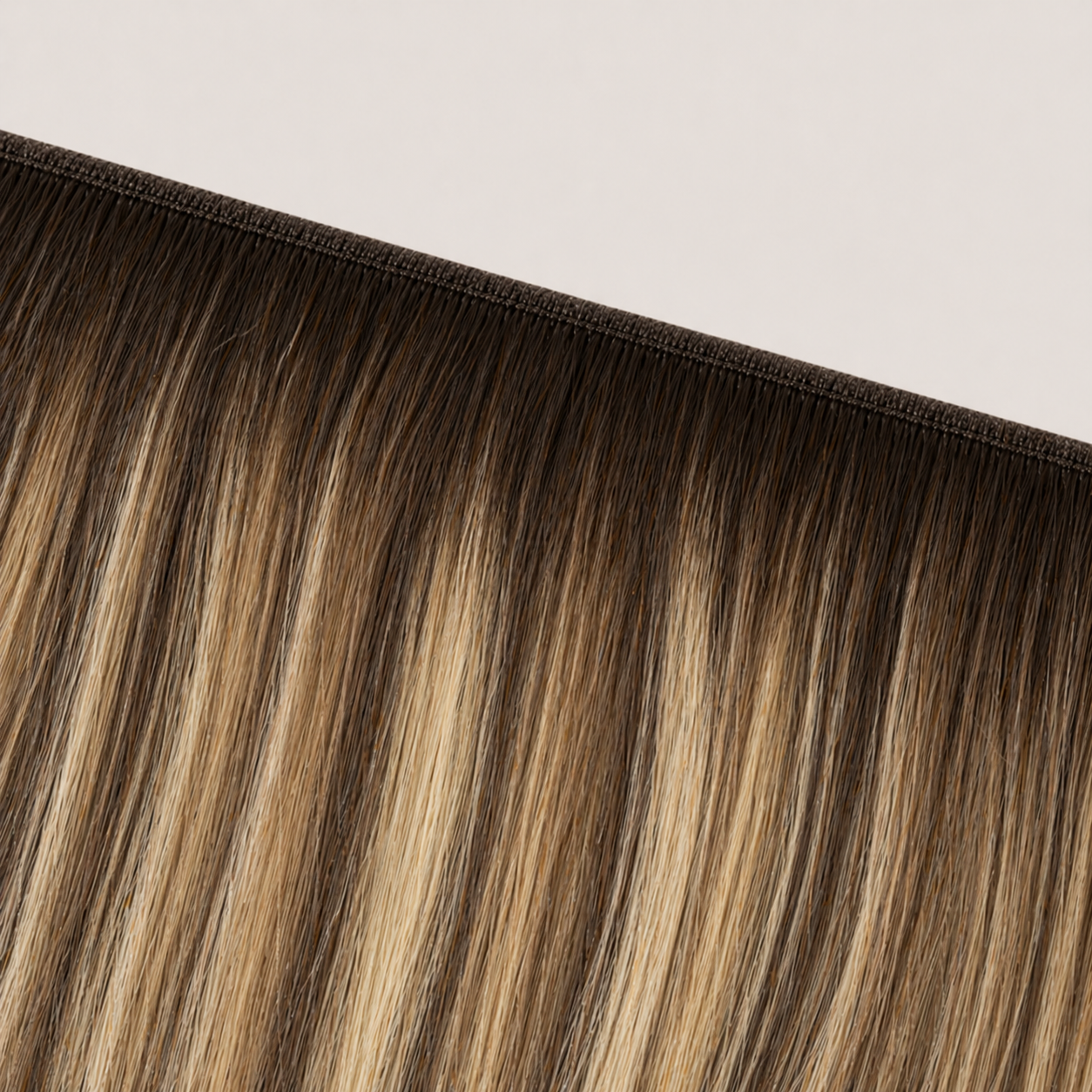 Flat butterfly weft seam of Stessia hair extensions in shade #4/8/18 Balayage